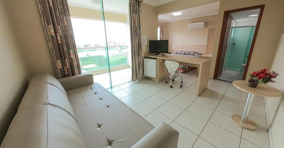 a living room with a couch and a desk at Águas do Paranoá in Caldas Novas