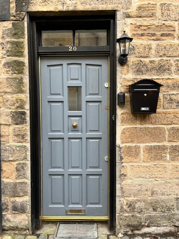een grijze deur op een bakstenen gebouw met een raam bij Very Central, Charlotte Square, near the Castle in Edinburgh