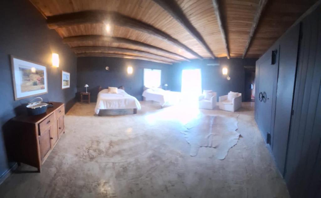 Großes Zimmer mit einem Bett und einer Holzdecke. in der Unterkunft El Paraíso Arroyito in Arroyito