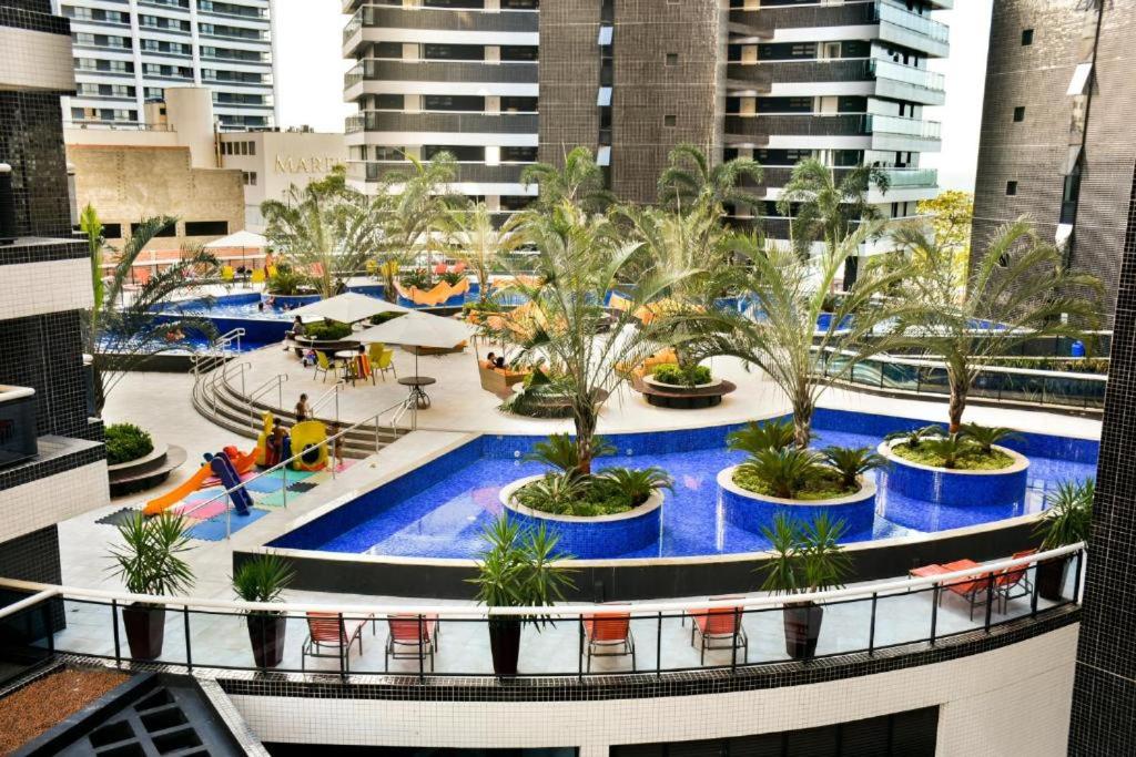 une grande piscine avec des palmiers dans un bâtiment dans l'établissement 405 - D NO MELHOR DE FORTALEZA Landscape, à Fortaleza
