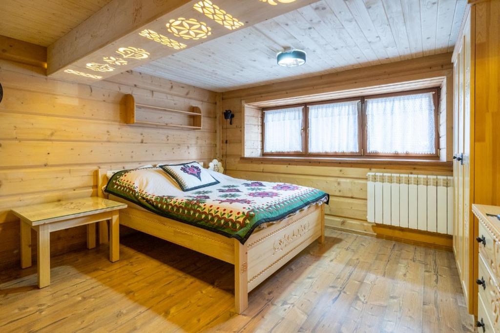 a bedroom with a bed in a wooden room at Willa Philla in Zakopane