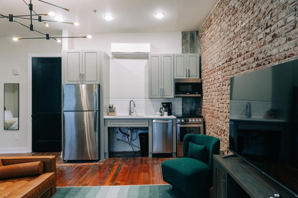 a kitchen with white cabinets and a brick wall at The St. Clair in Frankfort