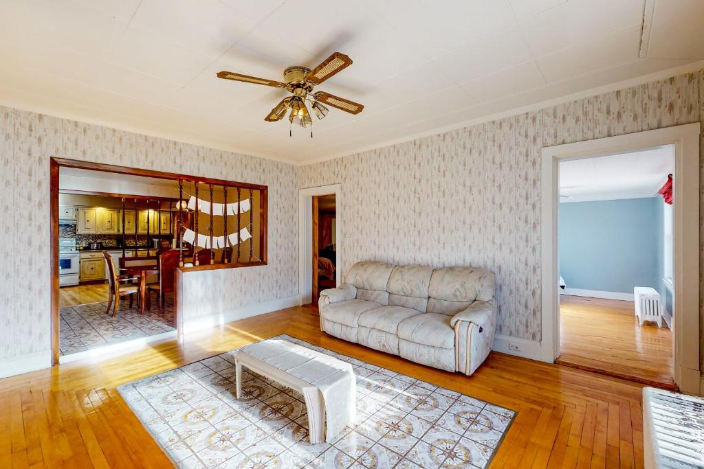 uma sala de estar com um sofá e uma ventoinha de tecto em The Crown of Maine on Main em Madawaska