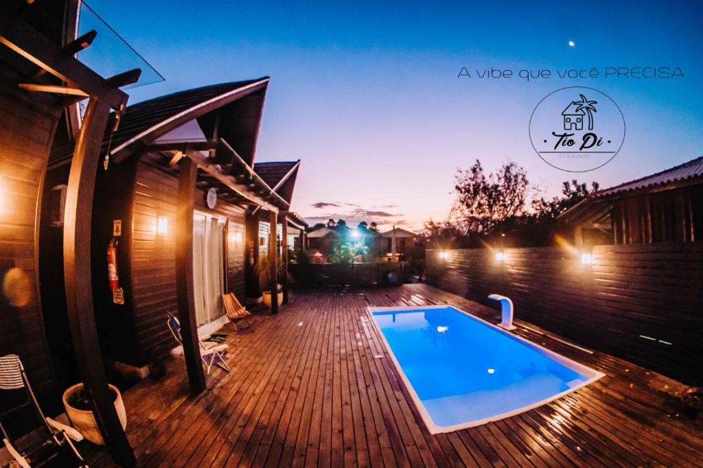 a house with a swimming pool on a wooden deck at Pousada Tio Pietro in Imbituba