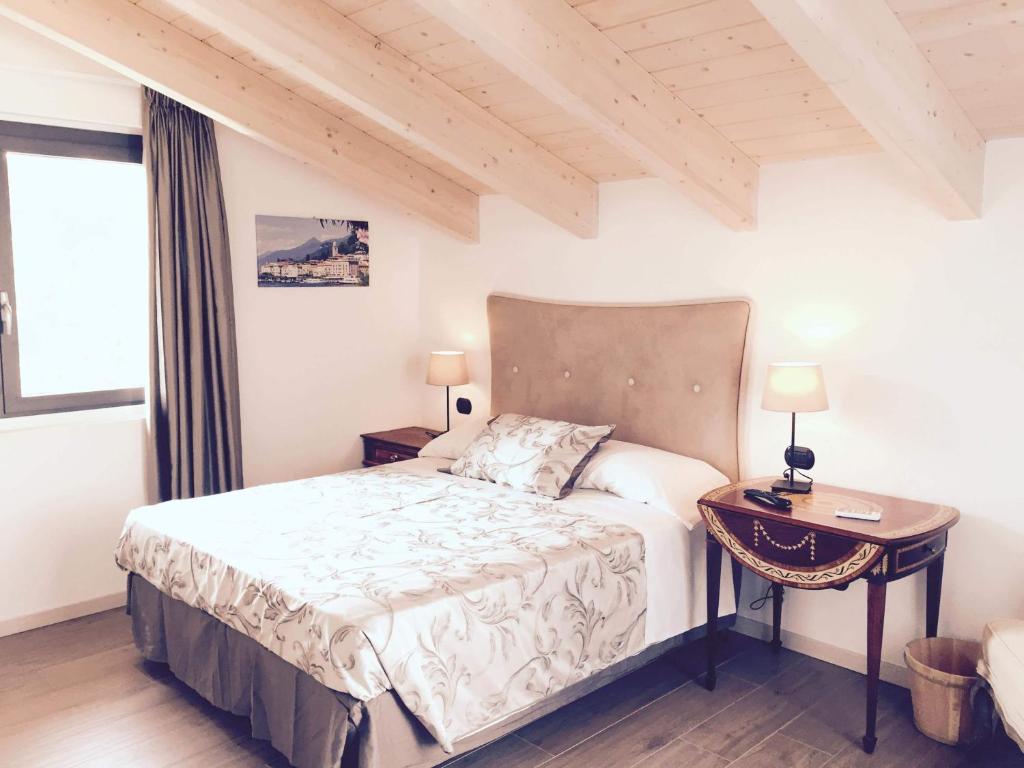 a bedroom with a bed and a table and a window at La Villa Bianca Guest house in Cantù
