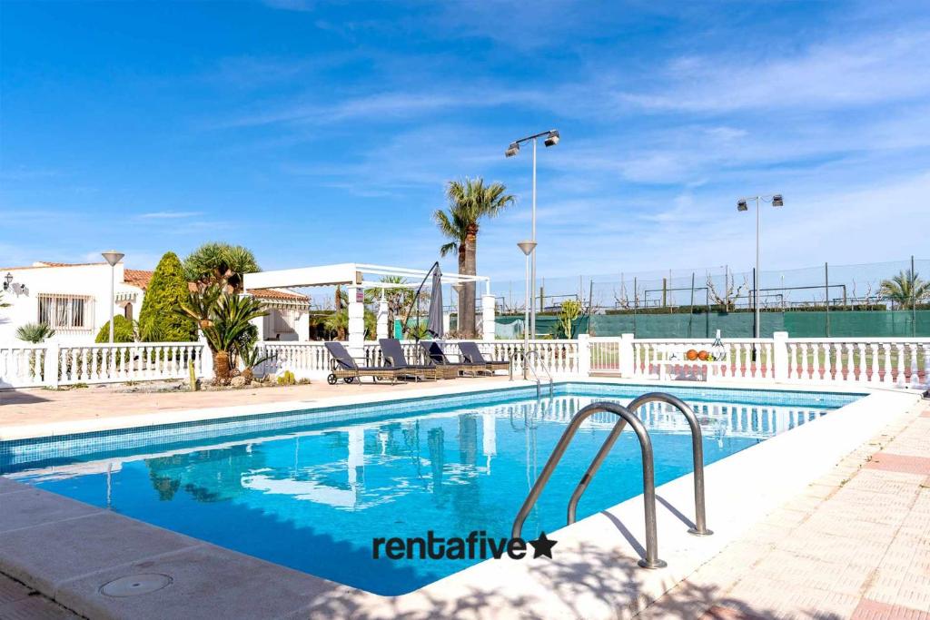 a swimming pool at a resort with a white fence at rentafive - Nuevo - A/A - Barbacoa - Tenis in Santa Pola