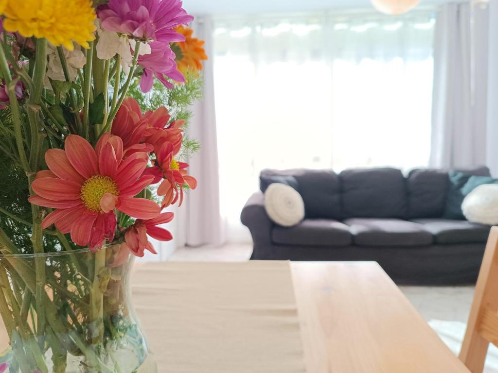 un jarrón lleno de flores sentado en una mesa en Apartamento en la Playa - Alicante, Costa Blanca - Los Olivos, en Alicante