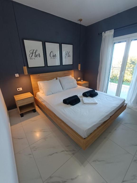 a bedroom with a large bed with three pictures on the wall at Alexander apartments in Spartià