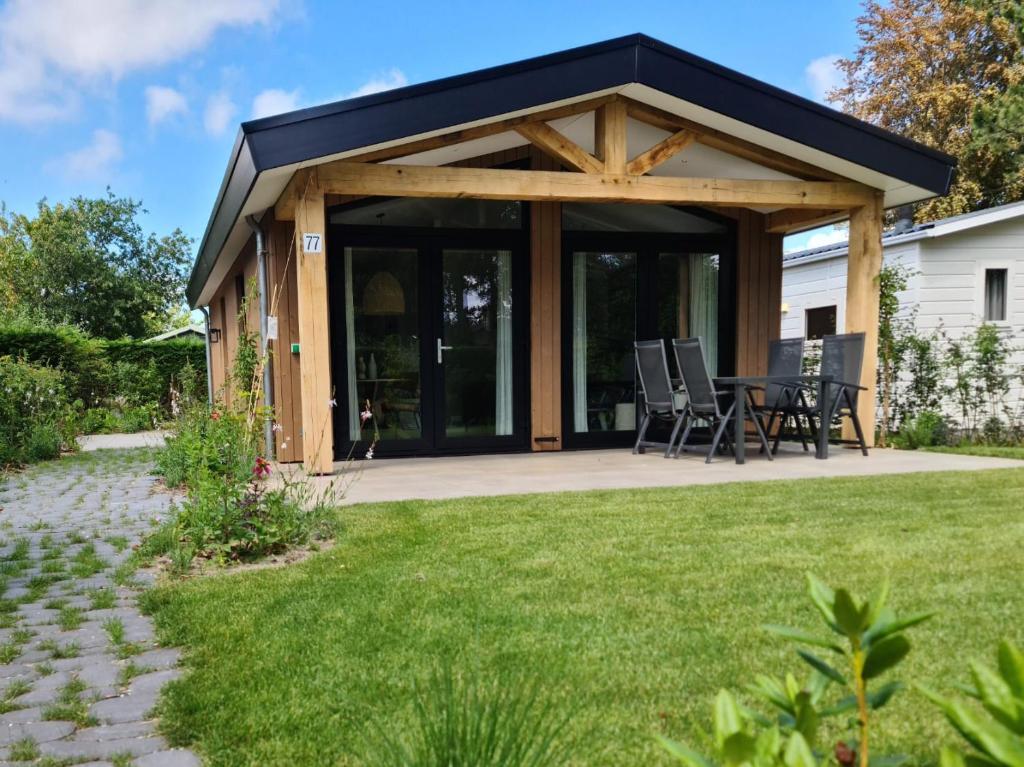 a pavilion with a table and chairs in a yard at Bungalowpark Mooyeveld in Egmond-Binnen
