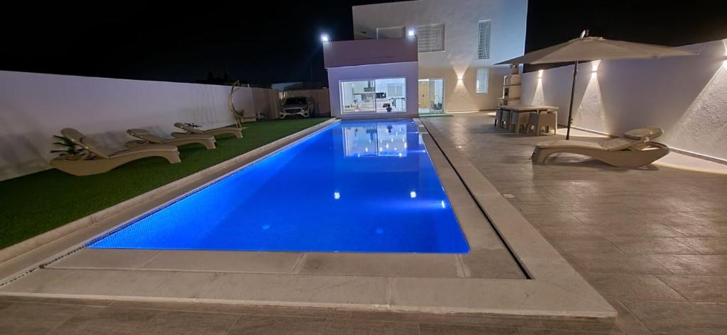 a swimming pool in a house at night at villa zak in Midoun