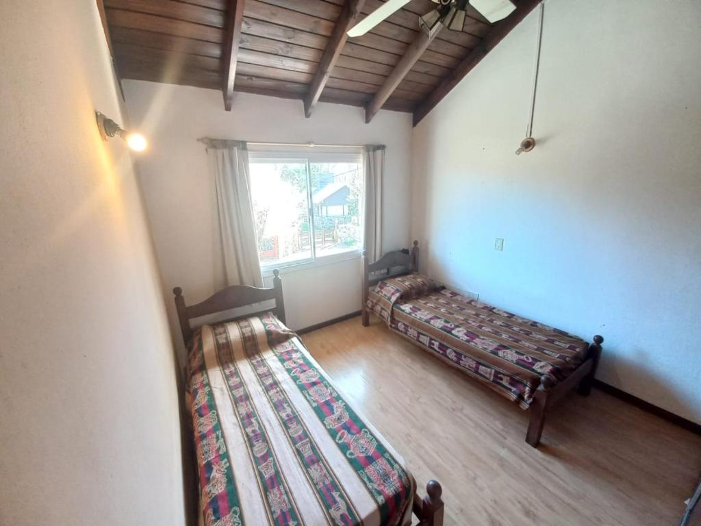 an attic room with two beds and a window at Tantanakuy in Villa General Belgrano