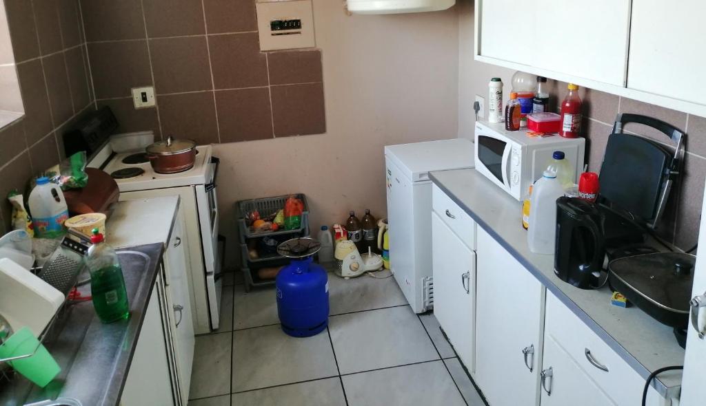 a small kitchen with a sink and a microwave at Room Blue in Pretoria