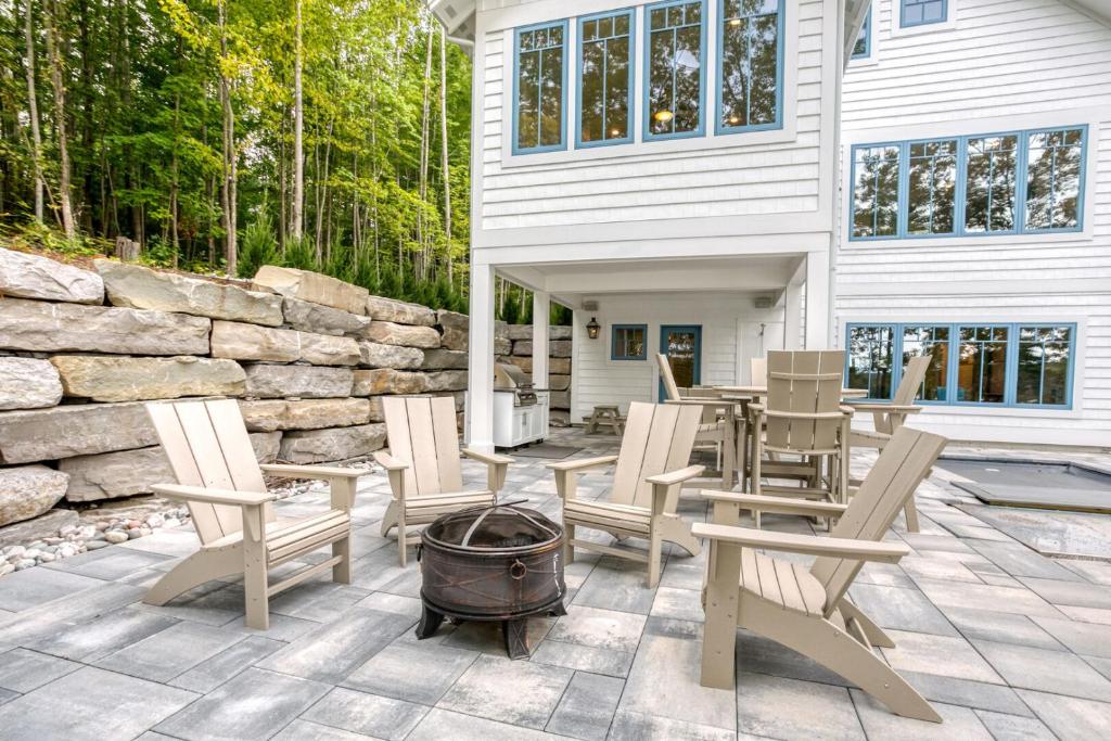 a patio with chairs and a grill and a house at Lakemore Resort in Traverse City