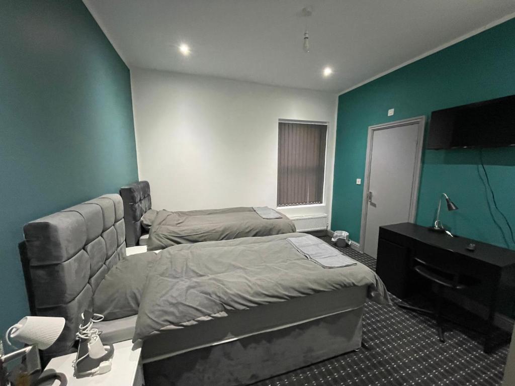a hotel room with two beds and a television at Luxurious En-suite Room 4 in Manchester