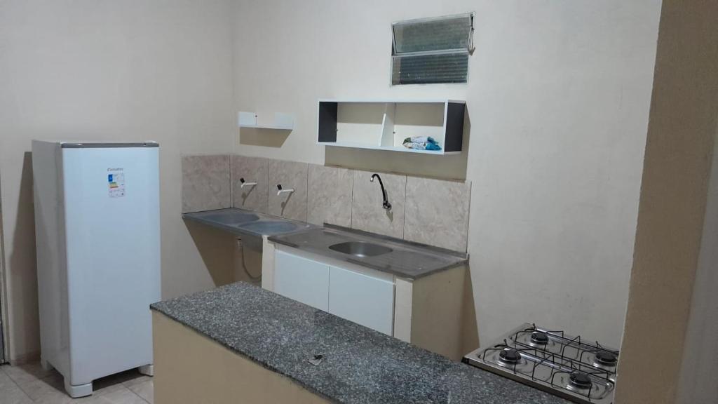 eine kleine Küche mit Spüle und Kühlschrank in der Unterkunft Hospedagem Domiciliar in Viçosa do Ceará