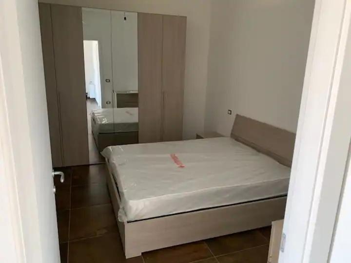 een kleine slaapkamer met een bed en een spiegel bij Appartamento Concio in Policoro