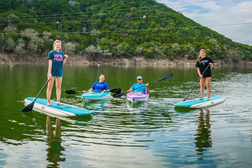 um grupo de pessoas em caiaques em um lago em Camp Sandy Lakefront, Pool,H Tub, Sand Volleyball em Austin