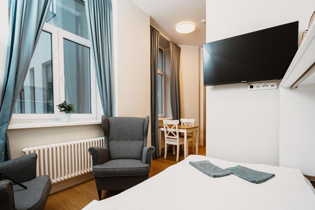 a room with a table and chairs and a tv at Stylish Central Apartment - 5 mins to Old Town in Riga