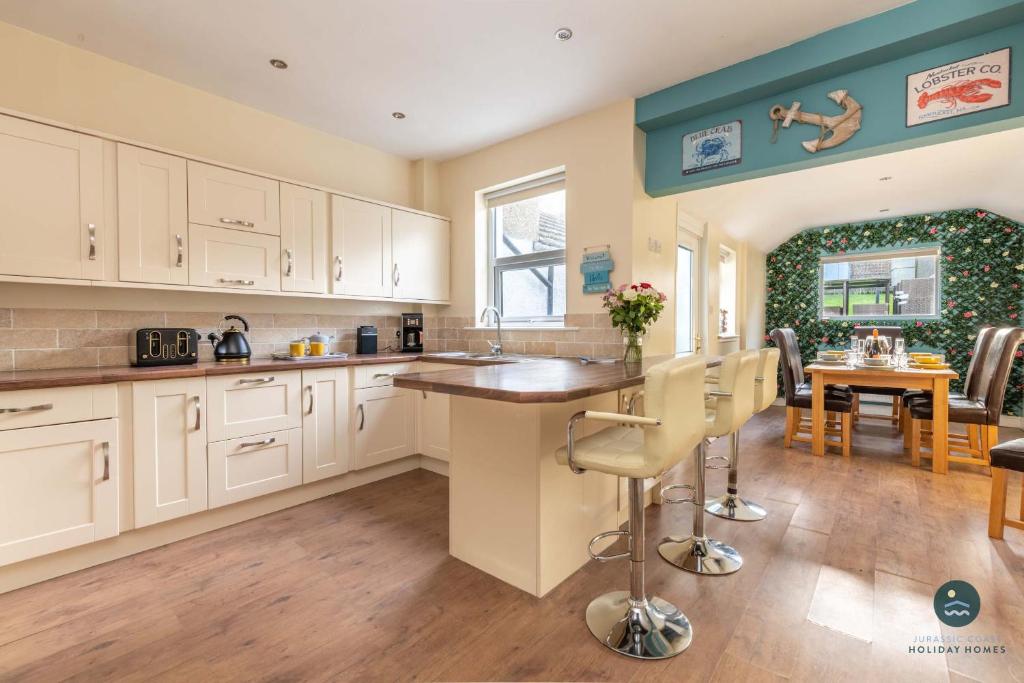 a kitchen with white cabinets and a dining room at Home & A'Wey - Holiday home near harbour in Weymouth