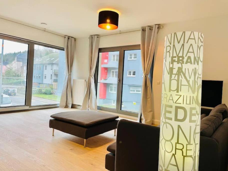 a living room with a couch and a large window at Luxury 2 bedrooms family flat in center w. Parking in Luxembourg