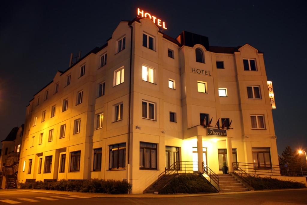 un gran edificio blanco con un cartel de hotel en Hotel Theresia en Kolín