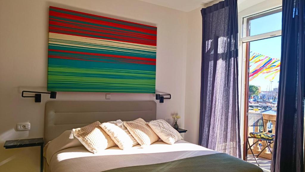 a bedroom with a bed with a colorful painting on the wall at City Life Rijeka in Rijeka