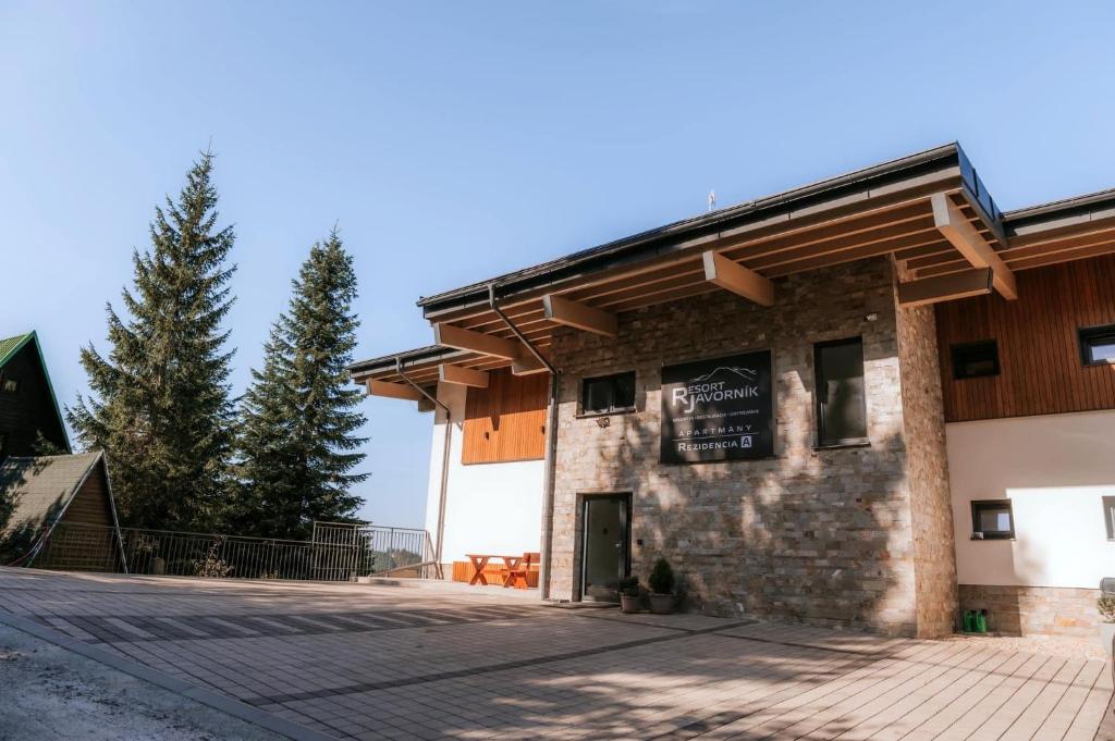 ein großes Steingebäude mit einem Holzdach in der Unterkunft Resort Javorníky in Makov