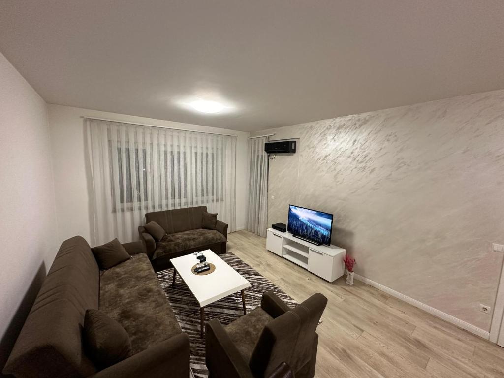 a living room with a couch and a tv at Lovely Family Apartment in Ferizaj