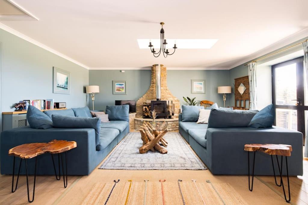 a living room with two blue couches and a fireplace at Stunning Renovation edge of Frome + country views in Frome