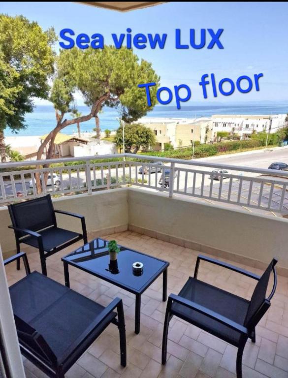 a patio with two chairs and a table on a balcony at BLUE EYES APARTMENTS in Ixia