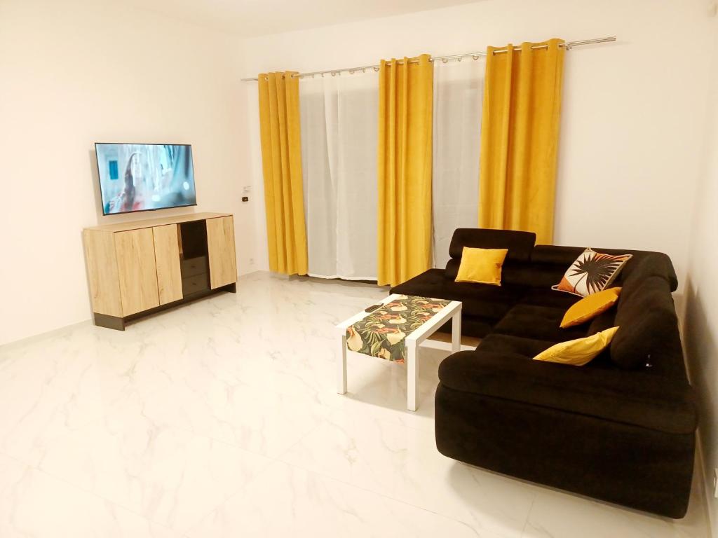 sala de estar con sofá negro y TV en AJP Exclusive House Szczecin en Szczecin