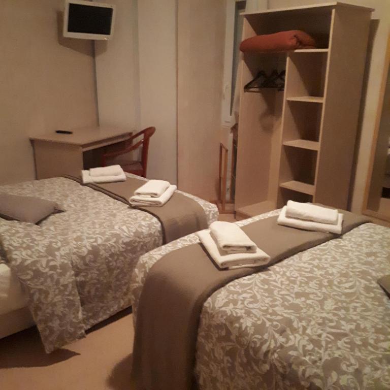 a room with three beds with towels on them at HOTEL RESTAURANT LE CENTRE in Comblanchien