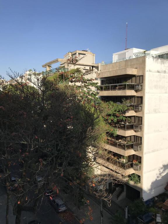 um edifício de apartamentos alto com uma árvore em frente em Charmoso Apartamento em Ipanema no Rio de Janeiro