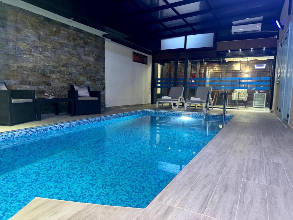 a large swimming pool with blue water in a building at Exclusive Spot in Niš