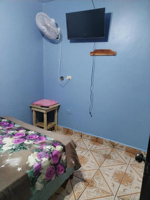 Habitación con cama y TV en la pared. en Hotel 24 /7, en Comayagua