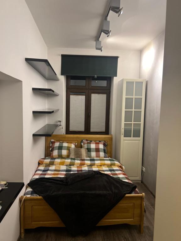 a bedroom with a bed with a checkered blanket at Apartament Starówka in Nowy Sącz