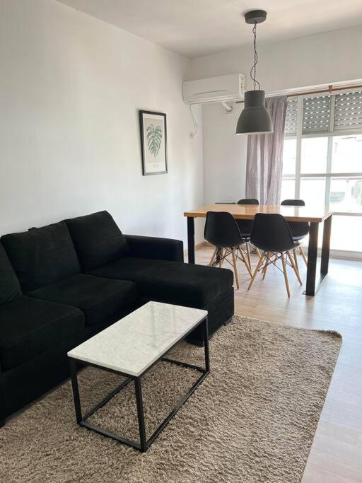 sala de estar con sofá negro y mesa en Apartamento en Belgrano en Buenos Aires