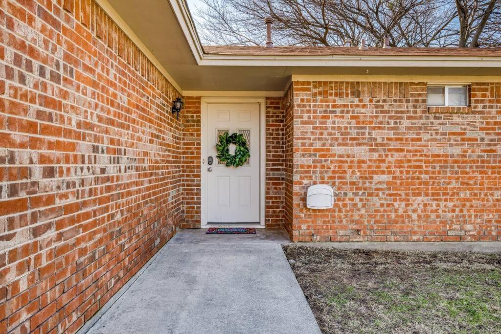 une maison en briques avec une porte blanche et une couronne dans l'établissement Centrally Located 3BR 2BA - !, à Denton