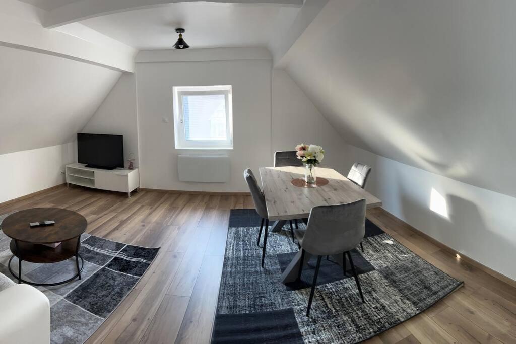 a living room with a table and chairs and a television at Appartement En Allemagne près de Strasbourg in Willstätt