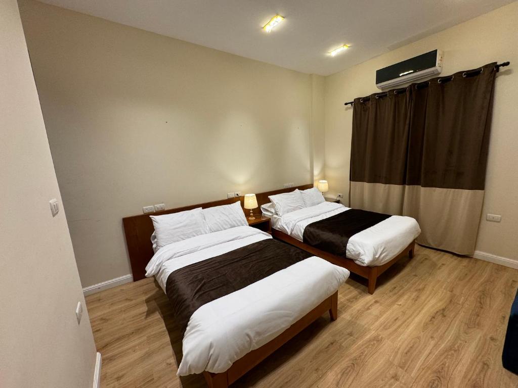 um quarto de hotel com duas camas e uma janela em Marron Serviced Studios and Rooms em Cairo