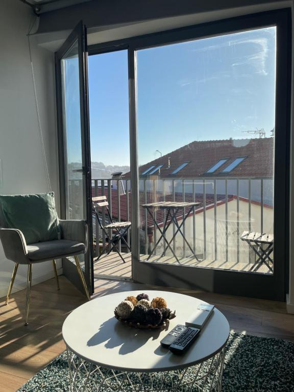 a living room with a table and a view of a balcony at Foz Douro in Porto