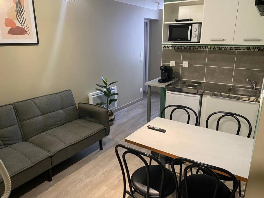 Appartement 2 - Hyper centre - 1 à 4 personnes في دويه: غرفة معيشة مع أريكة وطاولة ومطبخ