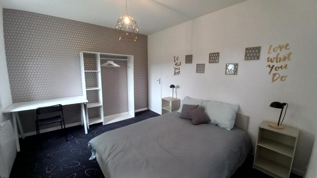 a bedroom with a bed and a desk and a window at Adorable studio avec entrée indépendante in Dijon