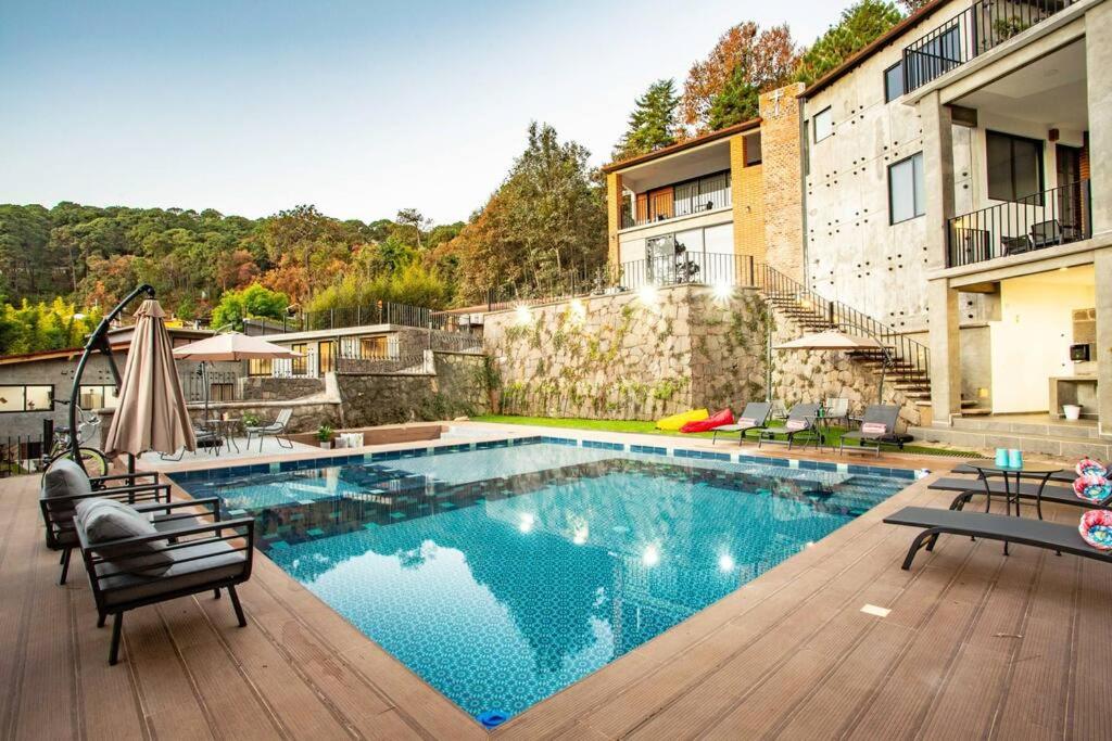 a swimming pool in the middle of a house at La Fábrica #5 Saint Gobain in Valle de Bravo