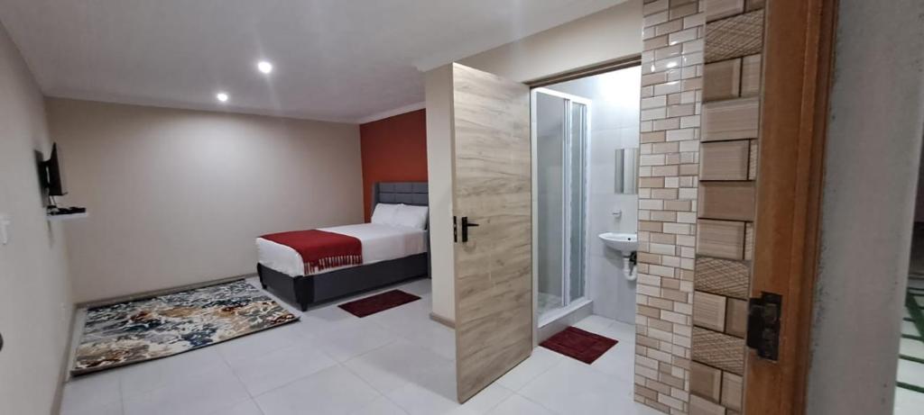 a bedroom with a bed and a bathroom with a shower at HARESCA LUXURY Accommodation Bellville in Cape Town