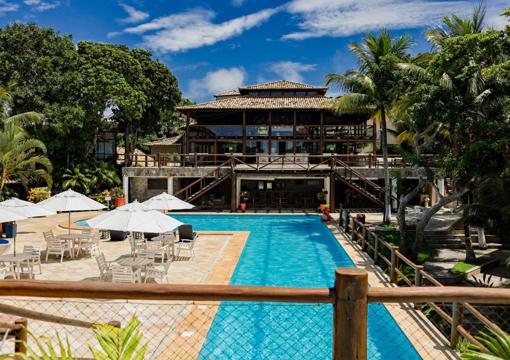 a resort with a swimming pool and a building at Pontal da Ferradura in Búzios