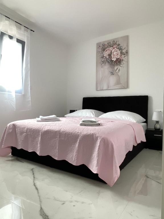 a bedroom with a bed with a pink blanket at Apartment Emanuel in Podstrana