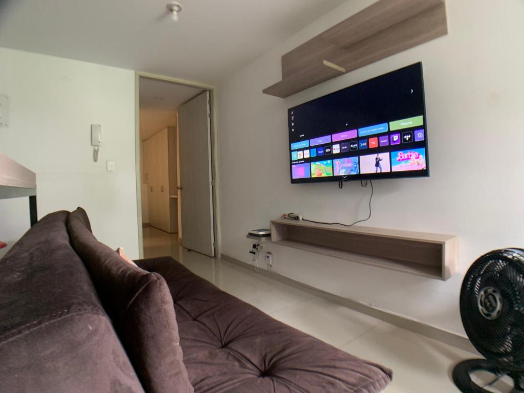 sala de estar con sofá y TV de pantalla plana en Apartaestudio en a Milla de oro, restaurantes, Centros comerciales, clínica Keralty, en Ibagué