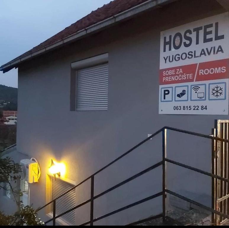 ein Haus mit einem Schild an der Seite in der Unterkunft Hostel Yugoslavija 1 in Aleksandrovac
