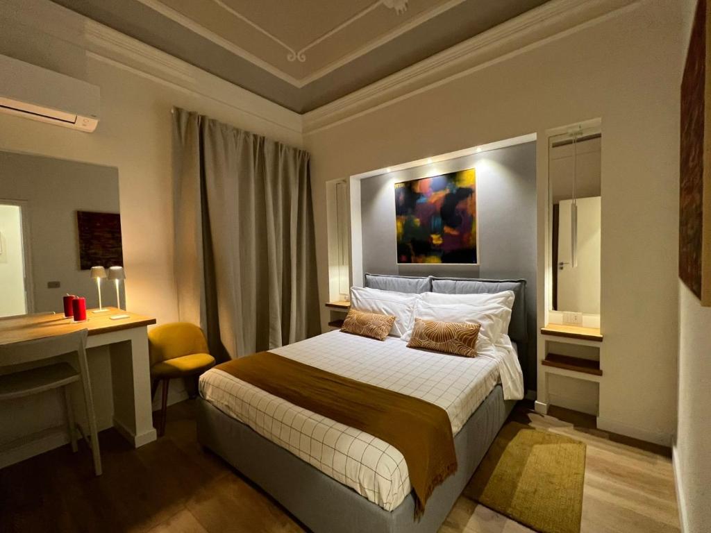 una camera con un letto, una scrivania e un quadro di ERASMO 19 Luxury Home a Catania